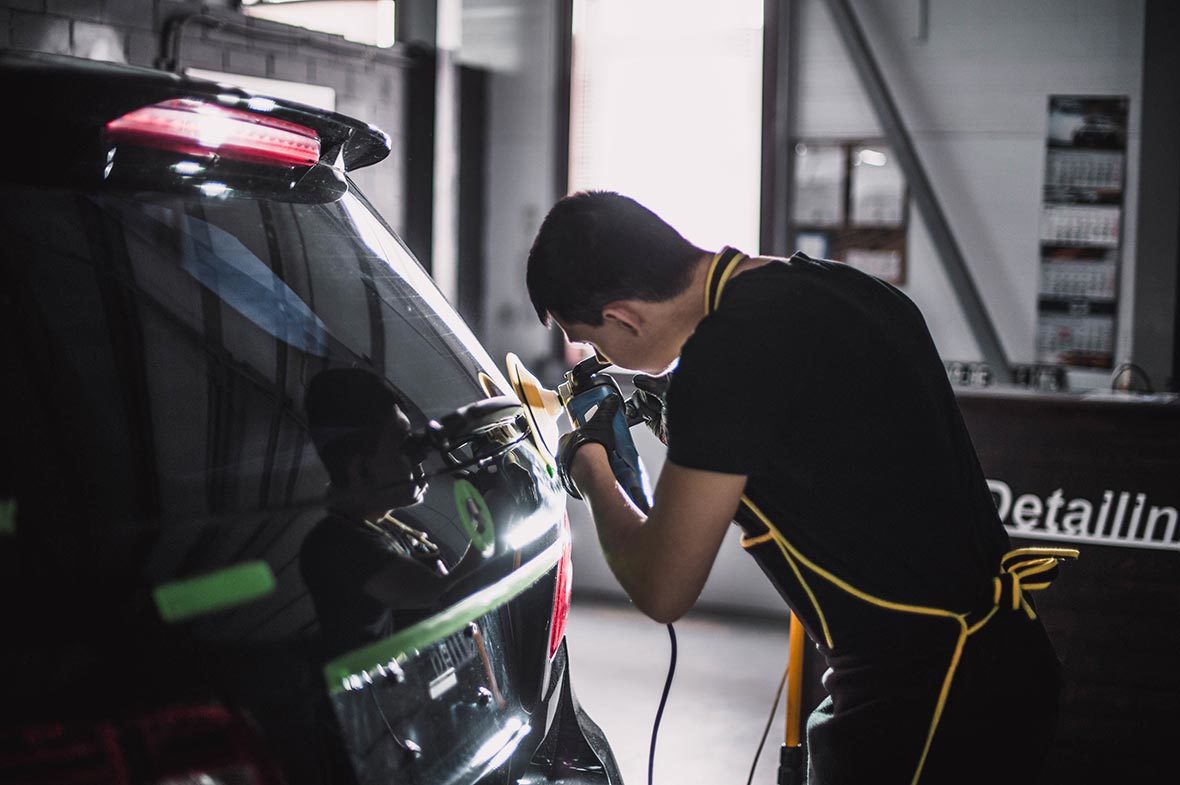 На фото мастер ателье AR-Detailing выполняет машинную полировку лакокрасочного покрытия автомобиля.