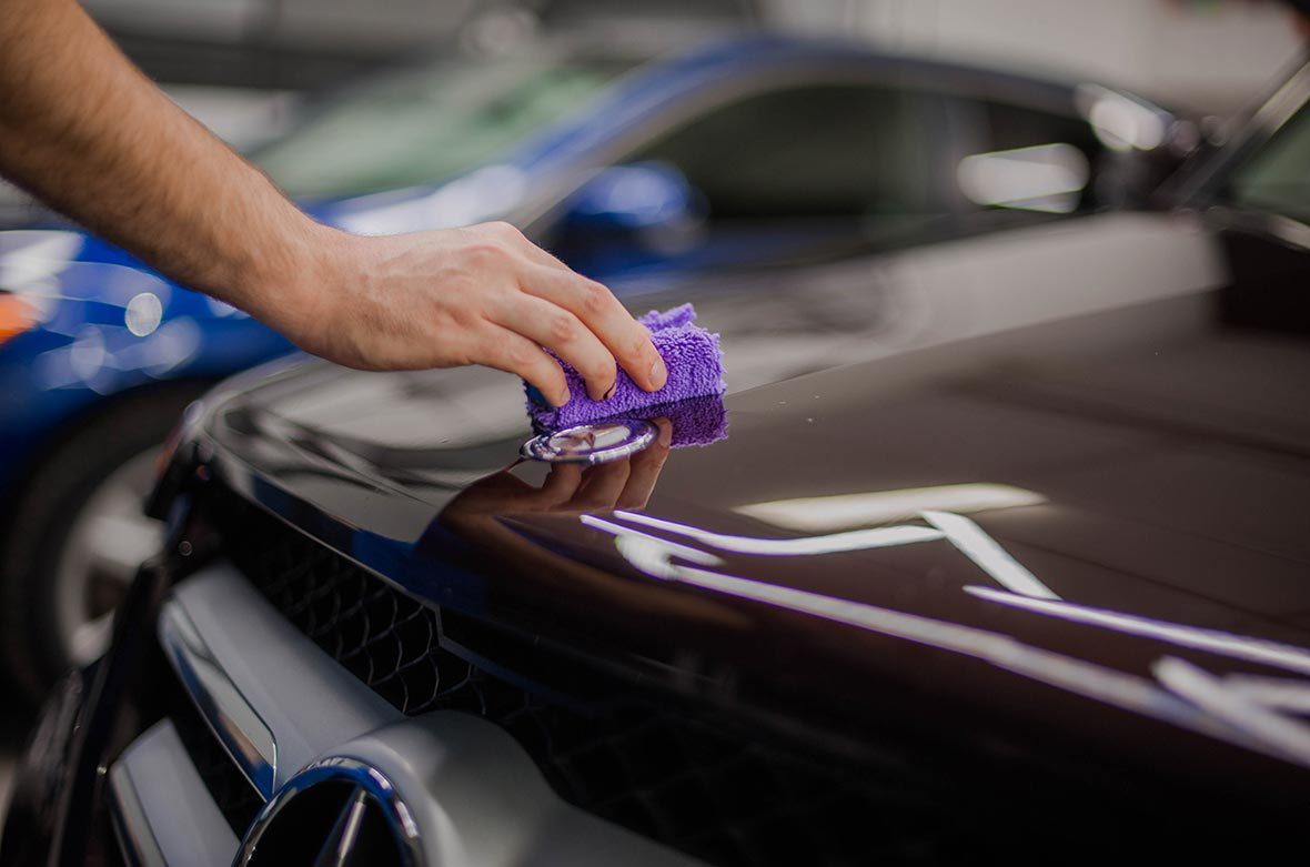 На фото мастер детейлинга AR-Detailing наносит жидкое покрытие на лакокрасочный слой автомобиля.