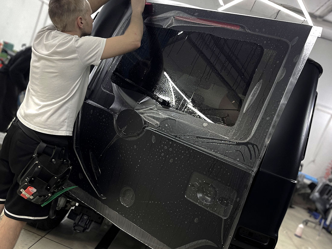 Смотреть на фото процесс оклейки защитной пленкой автомобиля Mercedes-Benz G-class.