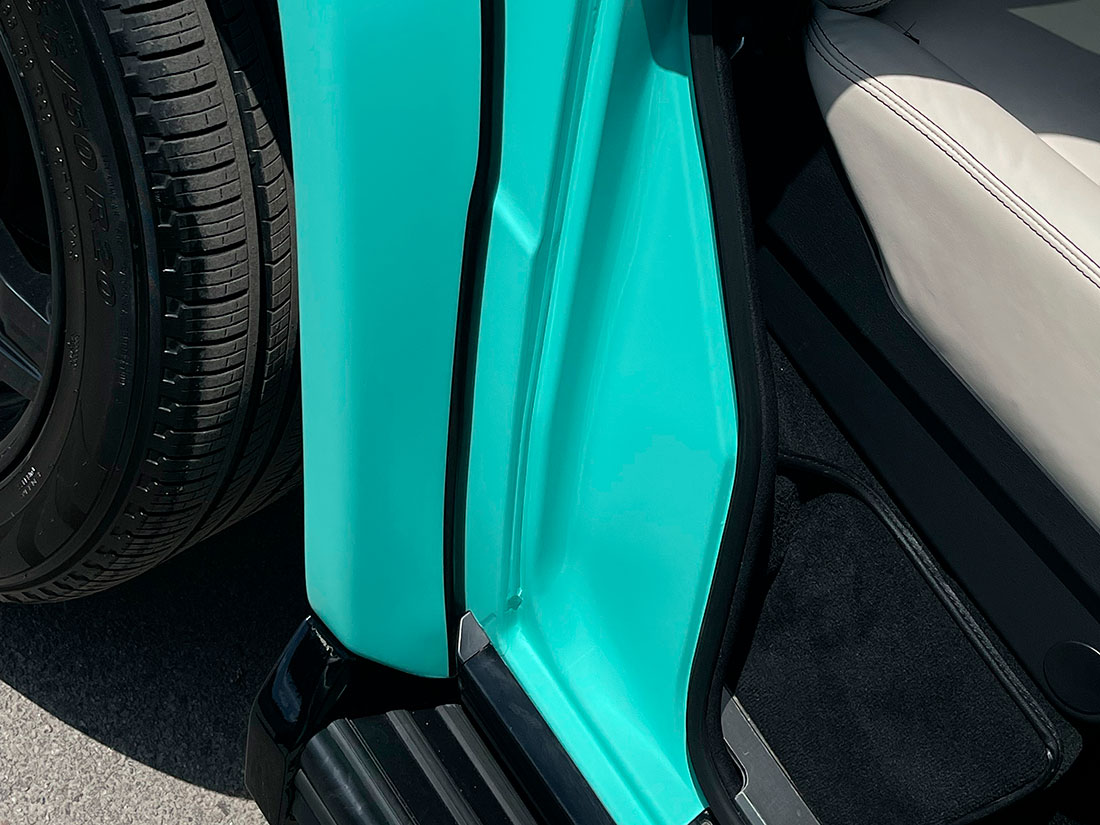 Смотреть на фото дверной проем автомобиля Mercedes-Benz G-класс после оклейки цветным винилом.