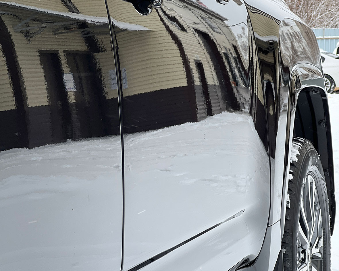Смотреть на фото крупным планом пленка на двери автомобиля Lexus LX600 черного цвета.