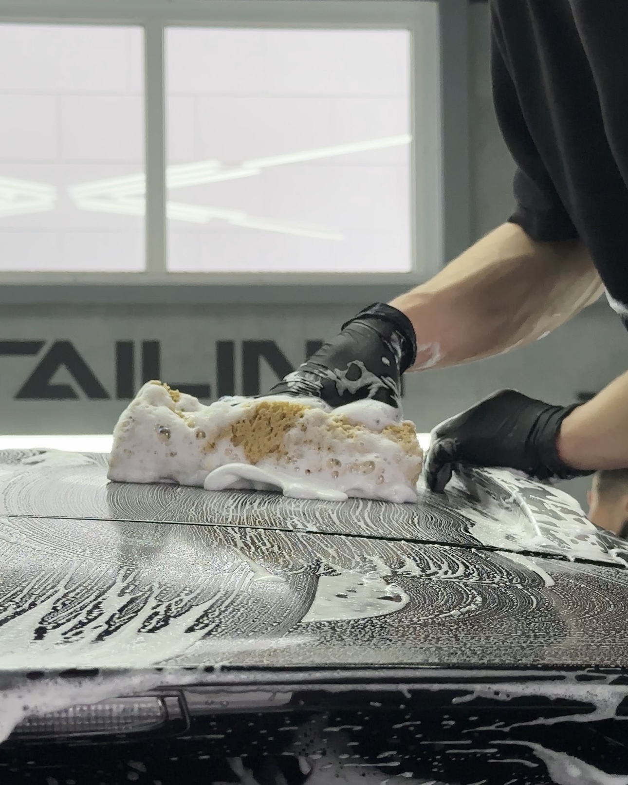 На фото мастер-технолог детейлинга AR-Detailing выполняет трехфазную наномойку автомобиля Porsche.