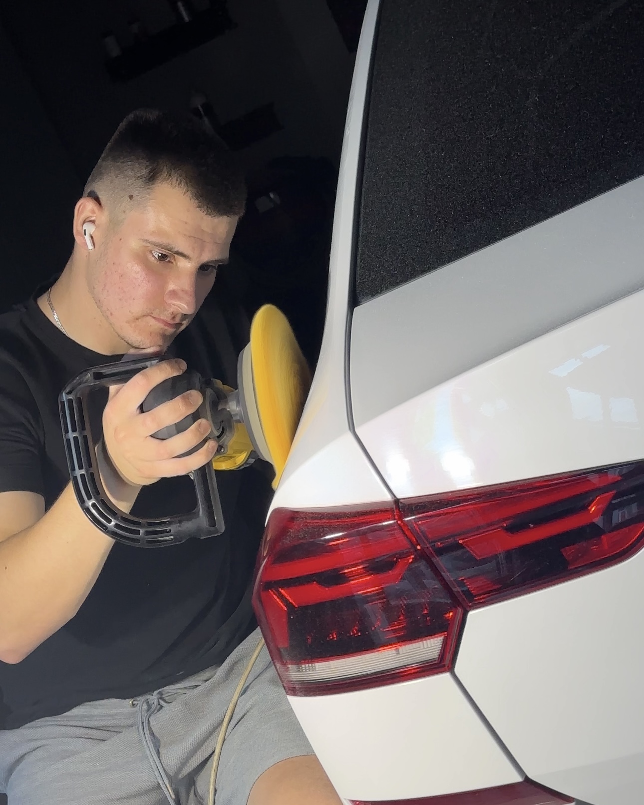 На фото мастер детейлинга AR-Detailing с полировальной машиной. Он убирает царапины на лкп автомобиля.