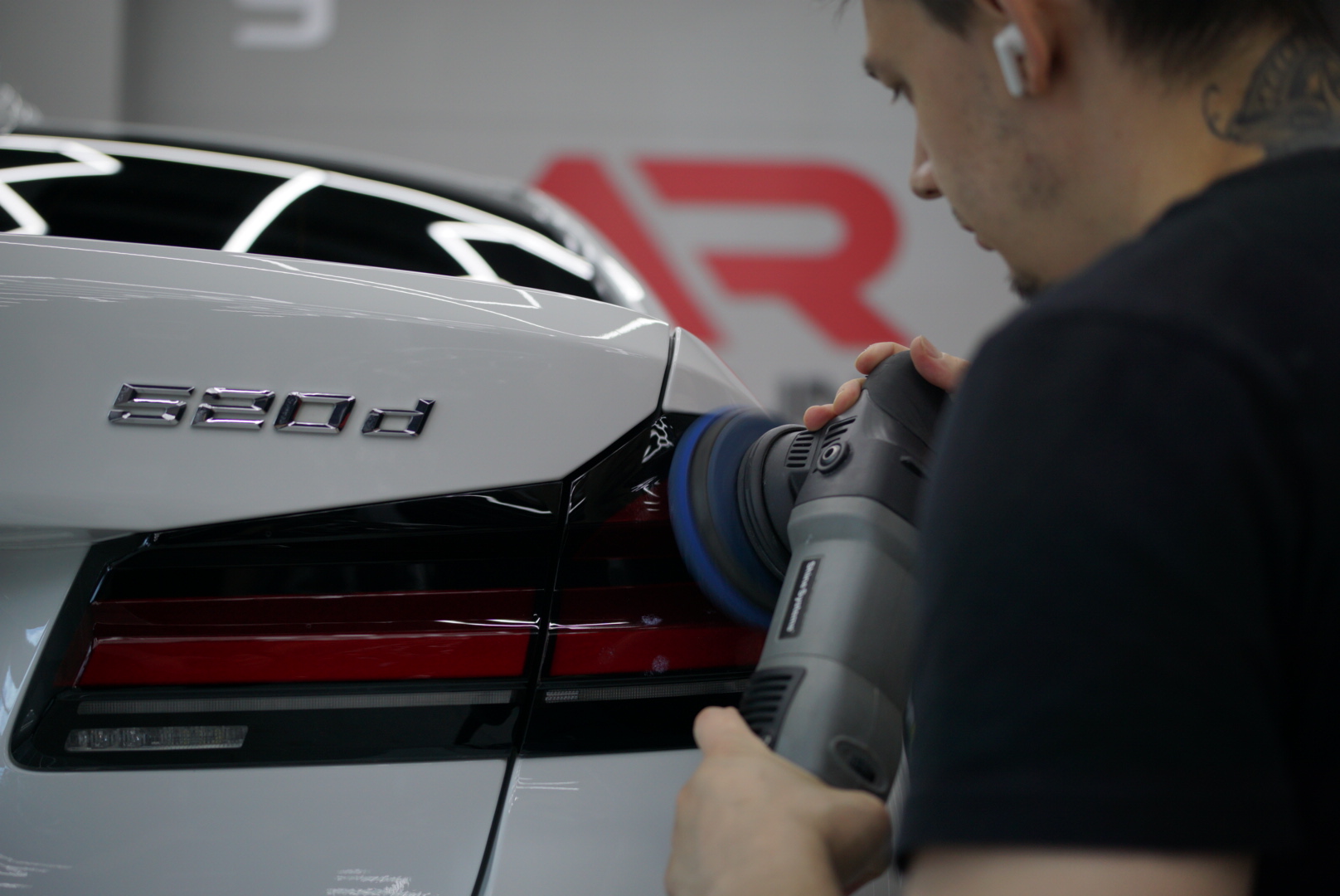 На фото мастер детейлинга AR-Detailing с полировальной машиной. Он убирает царапины на лкп автомобиля.